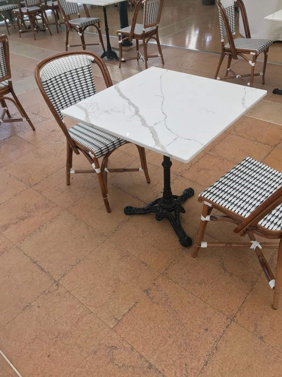Čtvercový stůl z materiálu TechniStone® z kolekce Crystal Calacatta Amnis a židle v kavárně Café de Paris