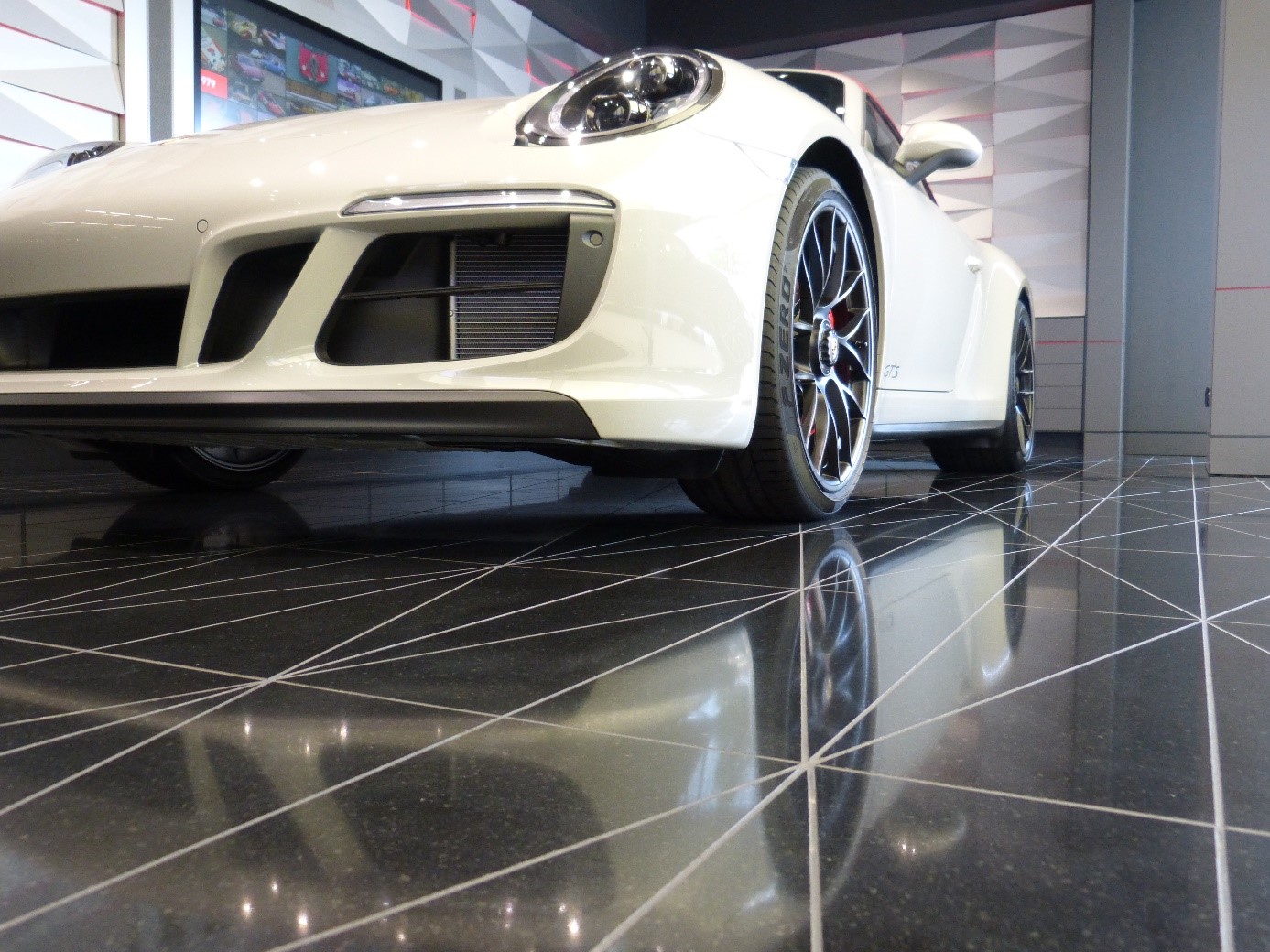 Nablýskané vůz Porsche a blyštivá dlažba dekorů Crystal polar white a Taurus Black od Technistone